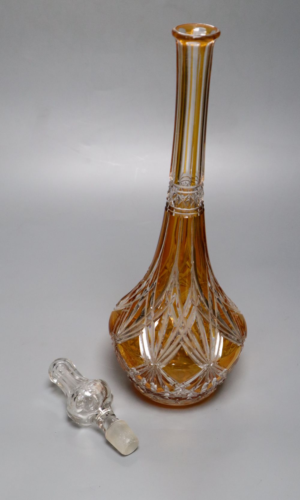 A tall amber-flashed glass decanter and clear stopper, height 48cm